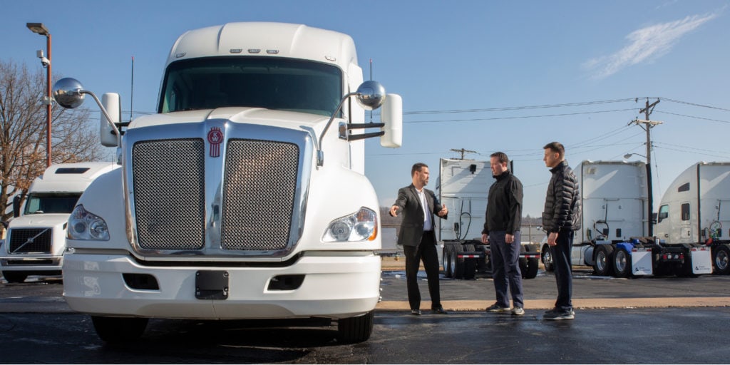 Trans Advantage employee talking to two men next to a truck