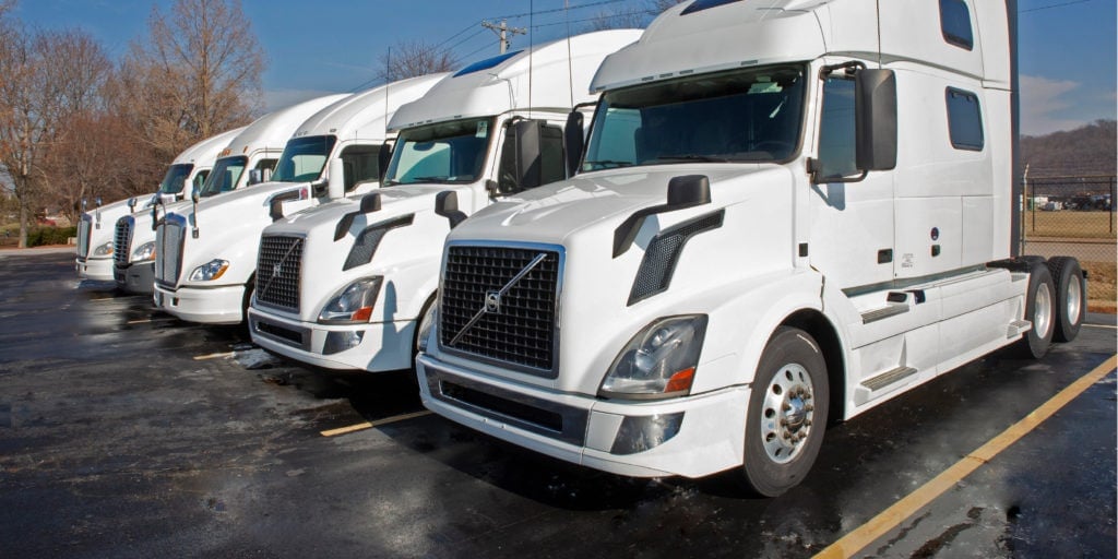 a row of trucks lined into parking spots